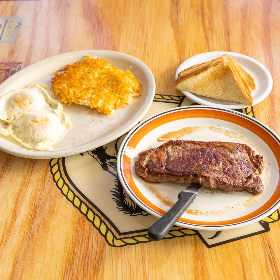 Steak and eggs with toast and hash browns.
