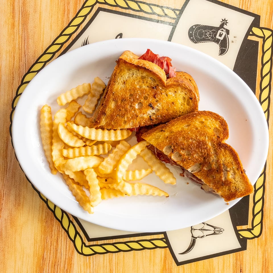 Reuben sandwich served with crinkle-cut fries.