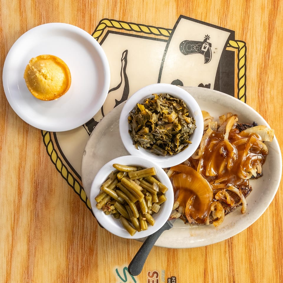 Liver and onions served with vegetables and cornbread.